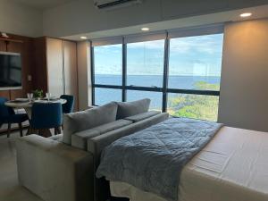 a bedroom with a bed and a view of the ocean at Tropical executive vista Rio in Manaus