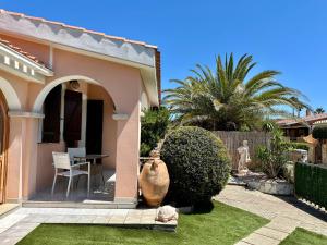 a home with a patio with a table in the yard at Villetta a schiera - Villasimius in Oasi dei Due Mari