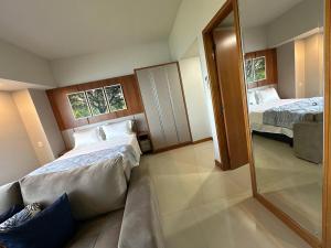 马瑙斯Tropical executive vista Rio的有两张床和一面镜子的酒店房间