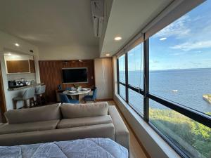 a living room with a couch and a view of the ocean at Tropical executive vista Rio in Manaus