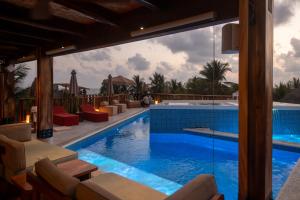 a pool at a resort with chairs and a table at Mantra Hotel Boutique in Puerto Escondido
