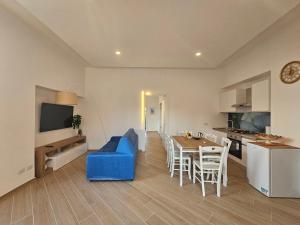 a living room and kitchen with a blue couch and a table at Acquamarina in Sant'Agnello