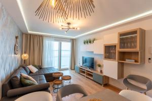 a living room with a couch and a tv at Sunset Resort 217 in Fonyód