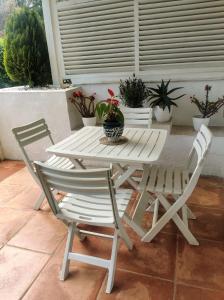 Biały stół i krzesła na patio z doniczkami w obiekcie Puerto Banus Apartment near beachfront, big sunny terrace, pool, tennis court, parking & movies projector w Marbelli