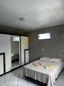 a bedroom with a bed and a mirror in it at Apartamento em Jequié para São João in Jequié