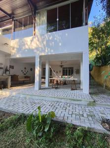 a large white house with a brick patio at Pousada Casa Cristal Mineiro in Santo Antônio do Pinhal +25 photos