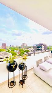 a balcony with a couch and plants on it at The Essence Studios, Accra Kotoka Airport in Accra