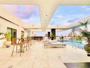 an indoor patio with a pool and tables and chairs at The Essence Studios, Accra Kotoka Airport in Accra