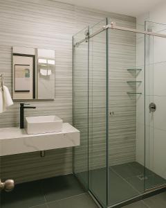 a bathroom with a sink and a glass shower at Hotel y Centro de Negocios YOEL in Atlacomulco de Fabela