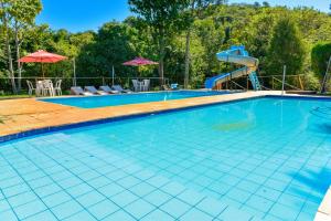 a swimming pool with a water slide in the background at CHACARA HORTOLAN in Mairinque