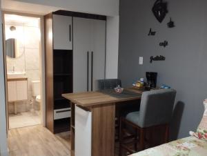 a kitchen with a table and chairs and a bathroom at Consulado Americano Studio 40 mts do Consulado do Estados Unidos in Porto Alegre +51 photos