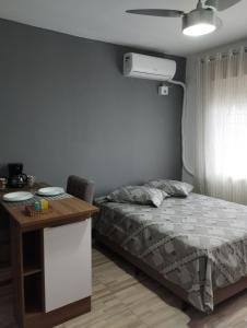 a bedroom with a bed and a desk and a bed and a table at Consulado Americano Studio 40 mts do Consulado do Estados Unidos in Porto Alegre