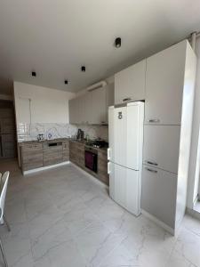 a kitchen with white cabinets and a white refrigerator at Чорновола,Порт Сіті in Luts'k +6 photos