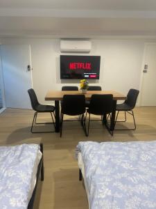 a dining room with a table and chairs and a tv at Bird Paradise In Bush setting in Bendigo