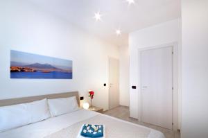 ein weißes Schlafzimmer mit einem Bett und einem Gemälde an der Wand in der Unterkunft Home Sweet Home in Neapel