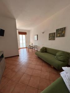 a living room with a green couch and a table at Casa Miralago in Menaggio