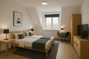 a bedroom with a bed and a flat screen tv at Pension Bockenem GbR in Bockenem