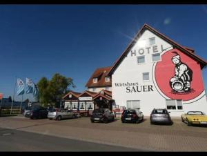 a hotel with cars parked in front of a building at Pension Bockenem in Bockenem