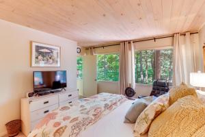a bedroom with a bed with a tv and a window at Woodsy Mountain Home Escape Walk to Marina! in Mountain Home