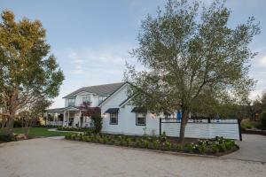a white house with a fence in the driveway at ONX WINES - Clark House & Apartment in Templeton
