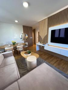 a living room with a couch and a flat screen tv at Ninth Cloud Apartman in Novi Sad