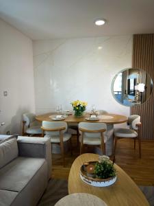 a living room with a couch and tables and a mirror at Ninth Cloud Apartman in Novi Sad