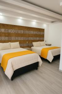 two beds in a hotel room with two bedsvisor at Hotel y Centro de Negocios YOEL in Atlacomulco de Fabela