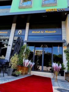 塔扎Hôtel Le Manoir的酒店前的红地毯