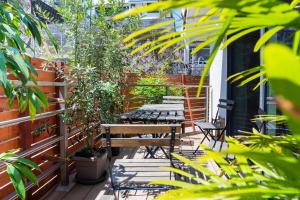 un patio con 2 mesas, sillas y plantas en Guest House Fu-ga, en Kagoshima