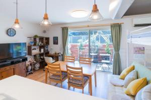 Una cocina y una sala de estar con mesa y sillas. en Guest House Fu-ga, en Kagoshima