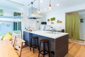cocina y sala de estar con encimera y taburetes en Guest House Fu-ga, en Kagoshima 4 fotos más