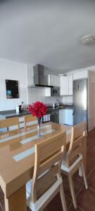 a kitchen with a table with a vase of red flowers at Flamingos view apartment in Cabo de Gata in El Pozo del Cabo