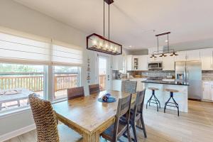 eine Küche und ein Esszimmer mit einem Holztisch und Stühlen in der Unterkunft Bale Oasis in Dauphin Island