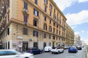 a busy city street with cars parked in front of a building at Minerva Boutique Suites in Rome