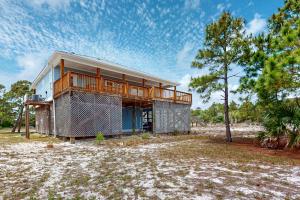 ein Haus mit einer Terrasse am Strand in der Unterkunft Bale Oasis in Dauphin Island