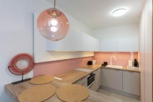 a kitchen with white cabinets and a wooden table at Sunset Resort 103 in Fonyód