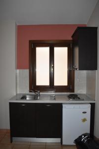 a kitchen with a sink and a window at Pansion Fani in Ouranoupoli