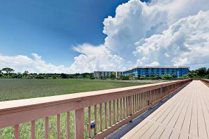 a wooden boardwalk with a building in the background at Hilton Head Resort 4313 in Hilton Head Island