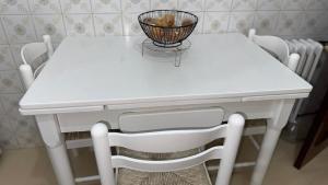 a white table and chairs with a basket on it at Entire apartment centro ponferrada in Ponferrada +9 photos