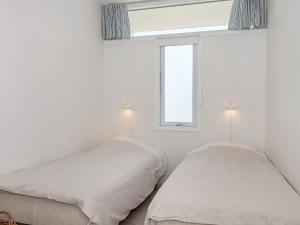 two beds in a white room with a window at 4 person holiday home on holiday park in Glesborg in Glesborg