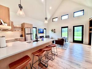 eine offene Küche und ein Wohnzimmer mit Theke und Hockern in der Unterkunft Hiker's Haven at Three Suns Cabins in Slade + 18 Fotos