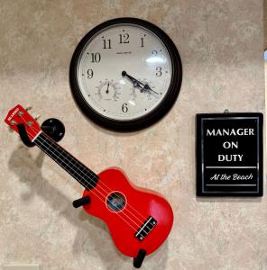 a clock and a red guitar on a wall at Hole Inn the Wall Hotel - Fort Walton Beach - Sunset Plaza - nearby Beaches & Hurlburt in Fort Walton Beach