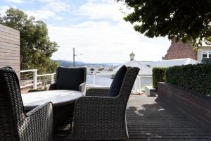 un grupo de sillas de mimbre y una mesa en un patio en Light-Filled Comfort Near Hospital & City, en Kings Park