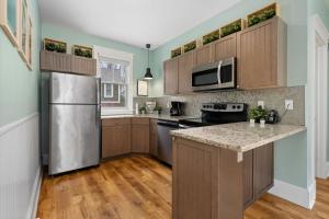 a kitchen with wooden cabinets and a stainless steel refrigerator at The Hemlock - 1 Hollow in Cherry Valley