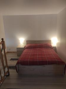 a bedroom with a bed and two lamps on two tables at Alpa au centre de Langon in Langon