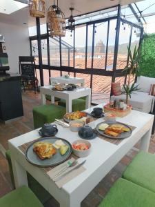 a white table with plates of food on it at Departamento con súper desayuno in Cusco