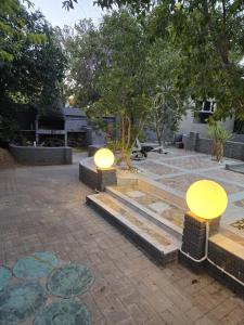 two lights on a patio with trees in the background at Oasiselfcatering guest house in Vosburg