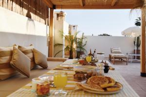a table with breakfast food and drinks on a patio at Riad Nūr in Marrakesh