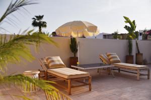 a patio with two chairs and a table and a table and chairs at Riad Nūr in Marrakesh