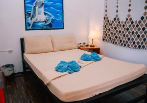a bed in a room with blue bows on it at Ananas Guesthouse in Moalboal
